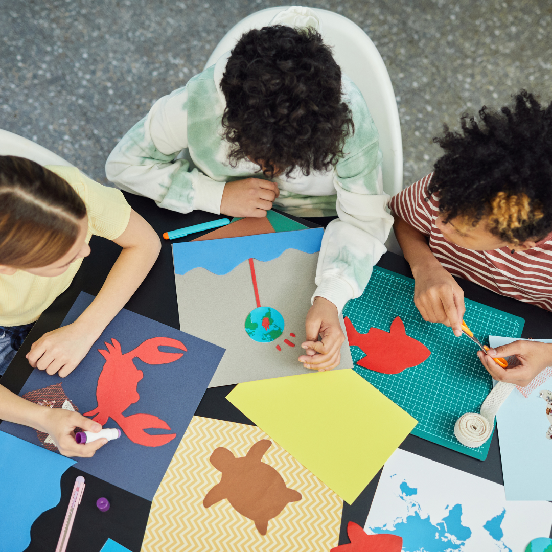 overhead view of children making arts and crafts together at a table